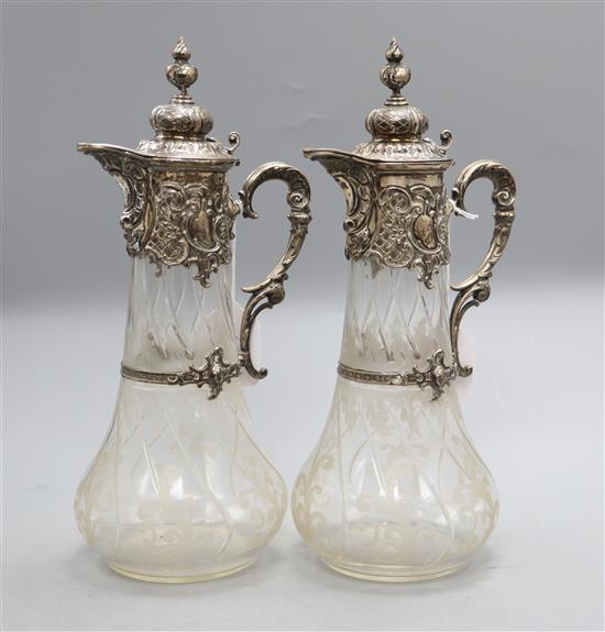 A pair of 19th century German 800 white metal mounted glass claret jugs,